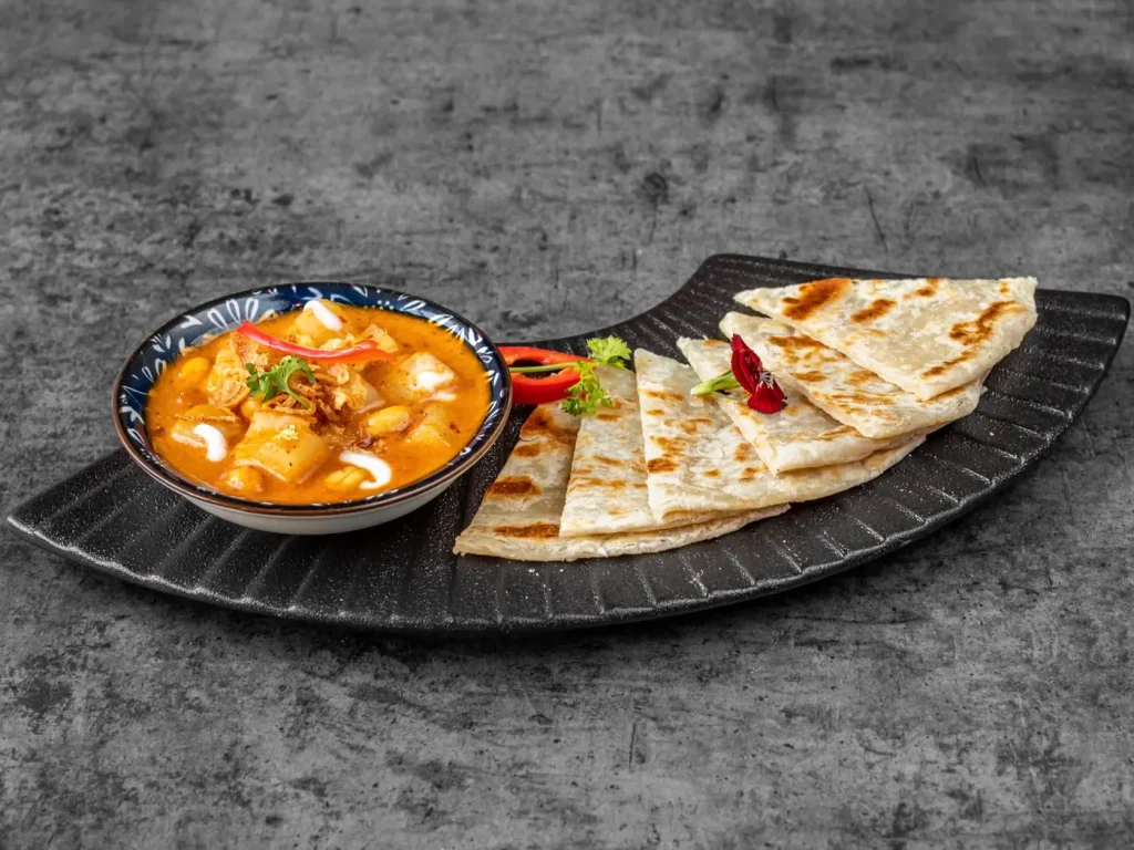 Flaky roti canai with massaman curry dipping sauce at Thai Food Near Me NYC